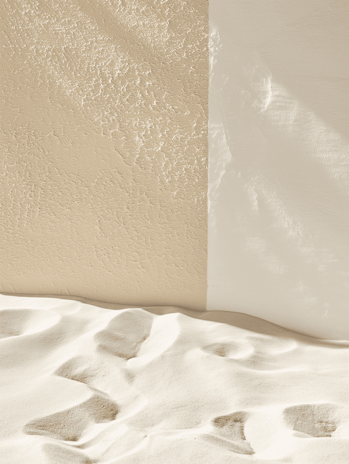 Textured earth wall beside smooth plaster and pale sand